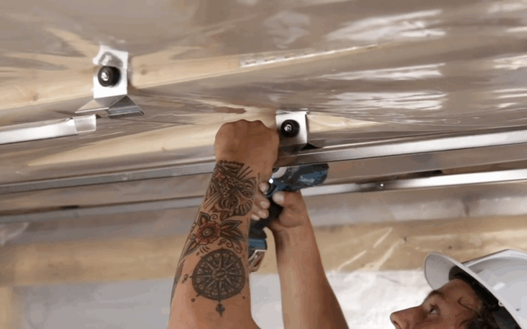 Decoupling ceiling vibrations with soundproofing installation for noise reduction in condos and apartments.